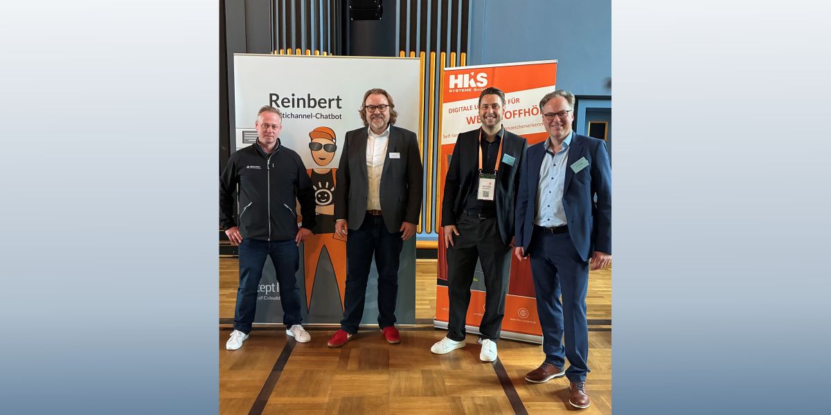 Vier Männer vor dem Aufsteller von Reinbert auf dem Kasseler Abfall- und Ressourcenforum 2026